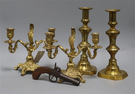 A pair of brass candelabra, a pair of brass candlesticks and a percussion pistol